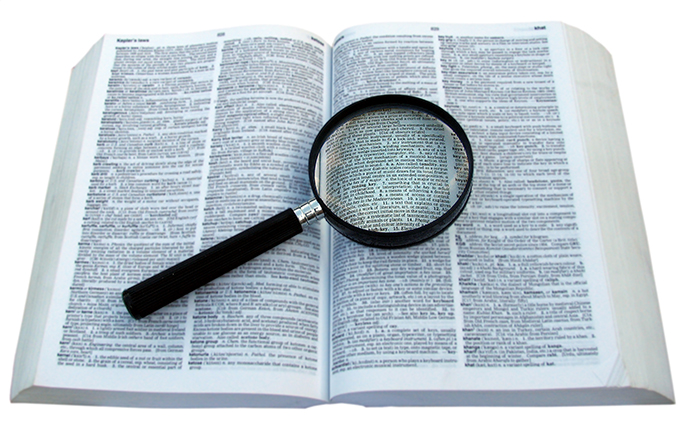 magnifying glass on dictionary