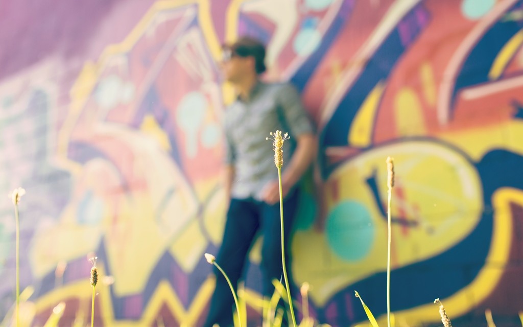 Man leaning on wall of graffiti