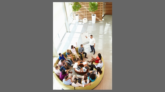 colleagues meeting at a round table one person presenting
