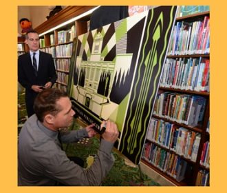 Los Angeles Mayor Eric Garcetti (left) watches artist Shepard Fairey sign a replica of LA’s first artist-designed, limited-edition library card at the press launch on April 19 at the Central Library. The card is available at all 73 locations of the Los Angeles Public Library.