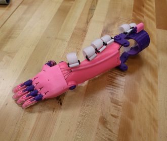 pink and purple prosthetic arm and hand