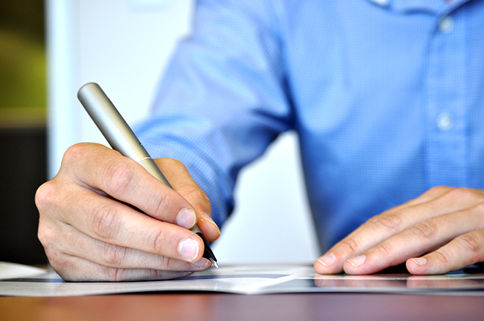 person hand writing a note