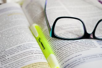 glasses on a book with a highlighter