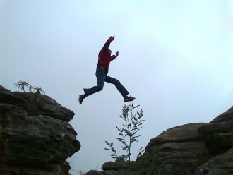 man leaping across a cliff