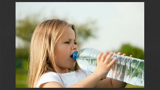 girl drinking a bottle of water