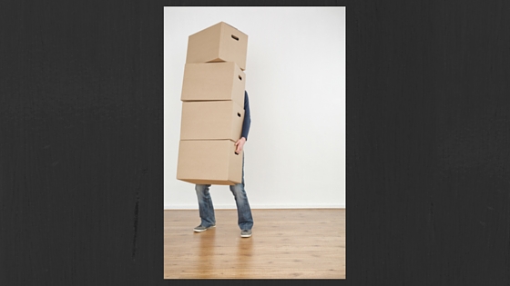 person holding several moving boxes