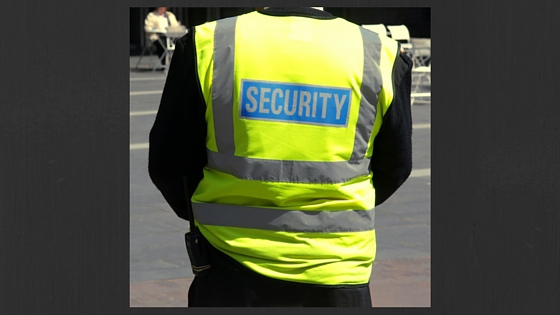 back of a person in yellow jacket with security written on it