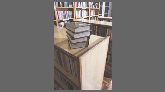 books on desk bookshelves in background