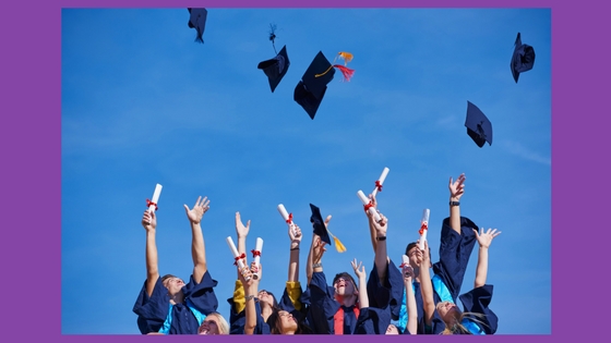 graduates tossing their caps in the air and holding diplomas