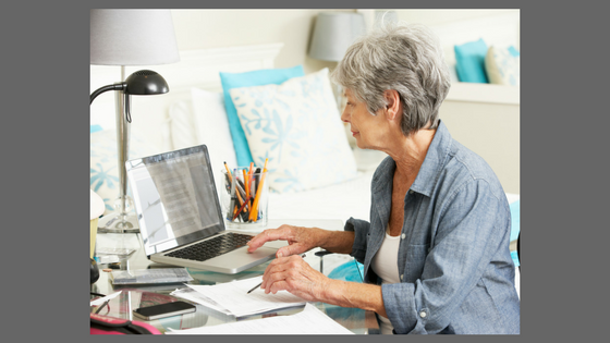 woman with gray hair working at a computer