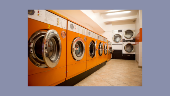 photo of a laundromat with large orange machines