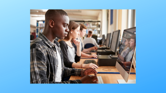 people working on desktops at a computer bank