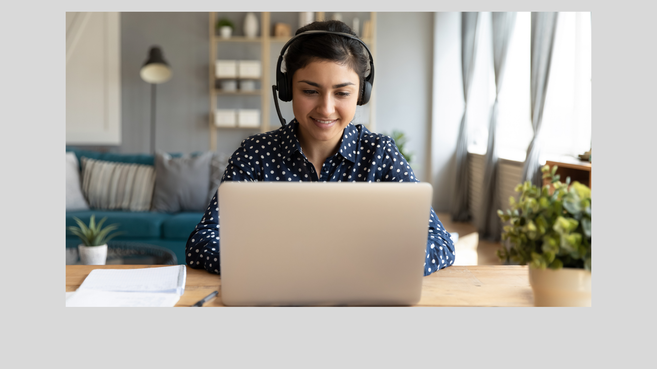 photo of a woman at a laptop with headphones