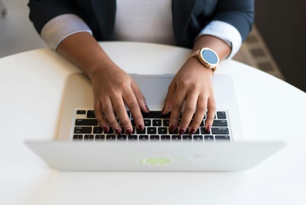 photo of hands typing on a laptop keyboard