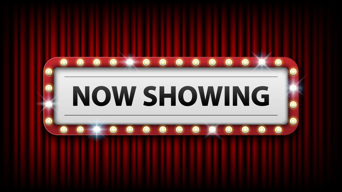 red curtains in background, white sign in lights, black letters that spell "Now showing"