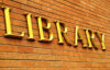 photograph of a brick building with large gold letters spelling library affixed to the brick